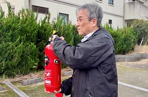 消火器の操作方法の説明をする職員