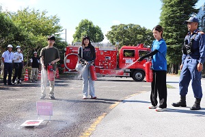 消火器による消火訓練をする女子学生