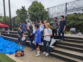 雨の中で選手を応援する学生たち